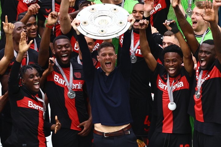 Xabi Alonso et les joueurs de Leverkusen brandissent le trophée de la Bundesliga © KEYSTONE/EPA/FILIP SINGER