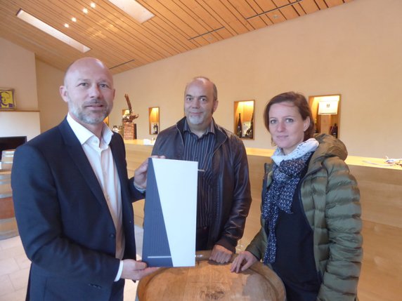 Sebastien Eberhard avec une maquette de présentation de panneau photovoltaïque coloré. À ses côtés, Yves Lehmann, du SENE et Laure-Emmanuelle Perret-Aeby, du CSEM. © Alexandre Cudré