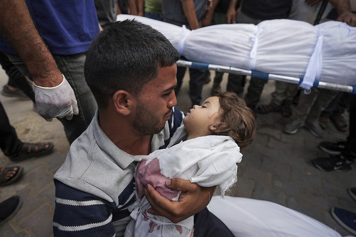 Dans la bande de Gaza, les bombardements israéliens n'ont pas cessé. Un homme tient le corps de sa petite fille de 2 ans tuée dans le centre de l'enclave,à Deir al Balah. © KEYSTONE/AP/Abdel Kareem Hana
