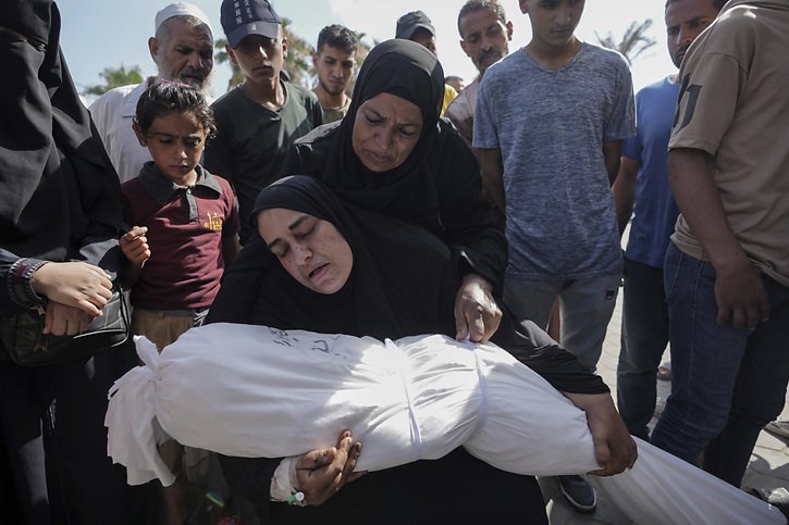 Une femme tient le corps de sa fille tuée dans un bombardement israélien sur un immeuble résidentiel du camp de réfugiés de Maghazi. © KEYSTONE/AP/Abdel Kareem Hana