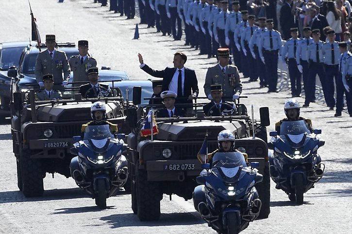 Emmanuel Macron mène le défilé du 14 juillet dans son véhicule de commandement. Exceptionnellement cette année à cause des Jeux olympiques, la manifestation s'est déroulée sur l'Avenue Foch, qui prolonge les Champs-Elysées après l'Arc de Triomphe. © KEYSTONE/AP/Michel Euler