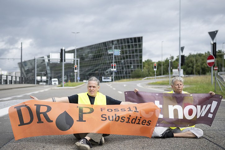 Les activistes pour la protection du climat ont bloqué la route menant à l'aéroport durant une dizaine de minutes. © KEYSTONE/ENNIO LEANZA